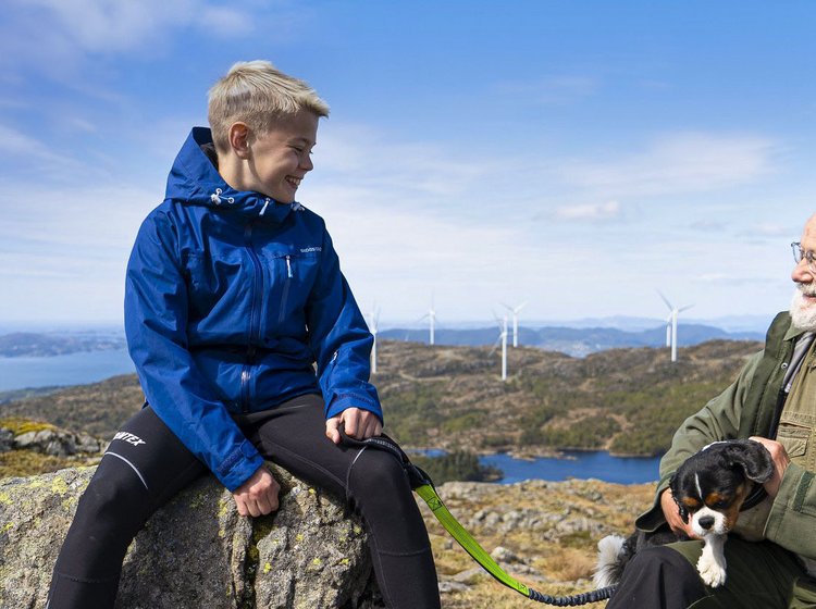 Enkel und Großvater vor einem Windpark